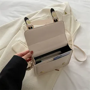 Beige minimalist messenger bag with magnetic buckle and adjustable shoulder strap