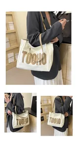 Detail showing the TOOHO letter patches on a large beige contrast shoulder tote bag