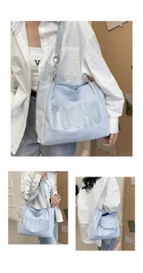 Detail of light blue tote bag with TOOHO lettering and metal chain shoulder strap