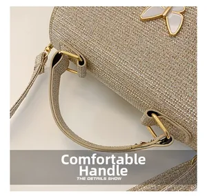 Détail du sac à main à paillettes champagne avec poignée confortable et accents dorés