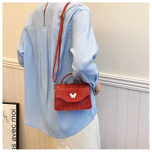 Petit sac à bandoulière rouge à paillettes avec fermoir papillon 3D sur haut bleu