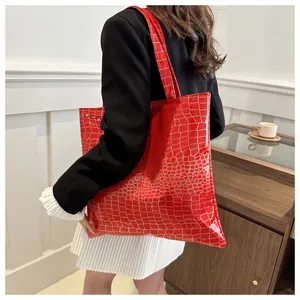 Detail of red crocodile texture tote bag styled with a professional black blazer outfit