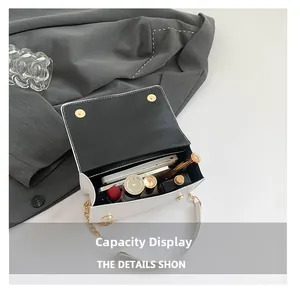 Internal capacity display of the white leather crossbody bag with chain strap