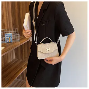 Détail de la boucle papillon sur le petit sac à main en paillettes champagne