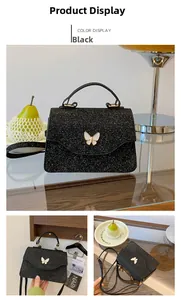 Détail du sac à main noir pailleté avec boucle papillon dorée et bandoulière élégante