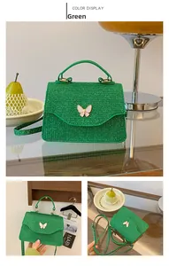 Vue détaillée du sac à main vert tissé et du détail décoratif du papillon blanc chic