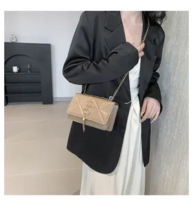 Detail view of khaki square shoulder bag with quilted pattern and gold chain strap