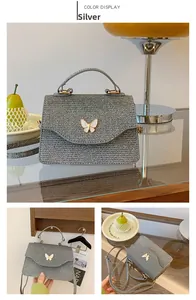 Sac à bandoulière tissé argenté avec papillon blanc présenté dans un intérieur doux