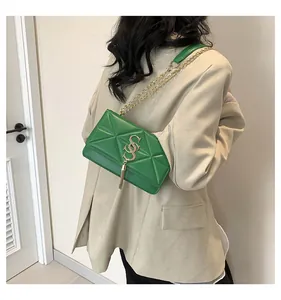 Detail of green crossbody bag showing geometric quilted pattern and gold tassel