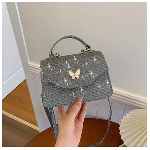 Vue détaillée du sac à paillettes argentées avec boucle papillon en métal et texture brillante
