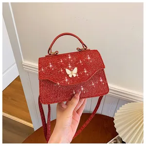Détail d'un sac à main rouge à paillettes avec un nœud papillon blanc en relief