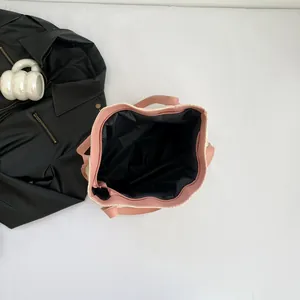 Contrast color straw tote bag with pink leather handles and zipper top closure