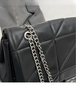 Makroaufnahme der schwarzen Stepptasche mit Silberkette und Metallösen-Hardware
