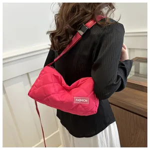 Macro detail of quilted puffer shoulder bag in hot pink with fashion logo strap and clip