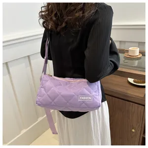 Detail view of purple quilted shoulder bag with diamond pattern and fashion label