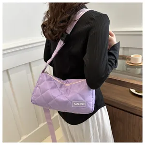 Detail of purple quilted shoulder bag showing the diamond stitch and fashion label