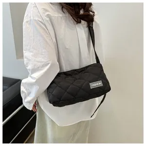 Close-up of black quilted shoulder bag featuring premium stitching and FASHION label