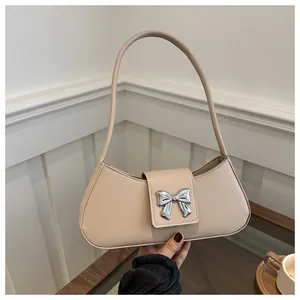 Detail of hobo shoulder bag with a polished silver butterfly buckle and beige finish