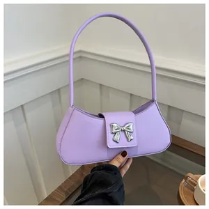 Detail of silver butterfly buckle on light purple leather shoulder bag