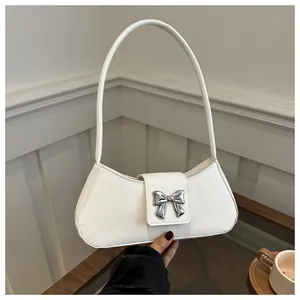 Detail of white PU leather bag featuring a silver metal butterfly buckle and sleek texture