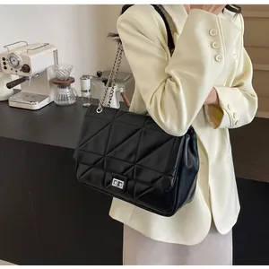 Detail der geometrischen Steppung und des silbernen Drehverschlusses an dieser Tragetasche