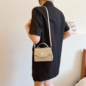 Mini sac à main pailleté or champagne avec boucle papillon blanche et bandoulière