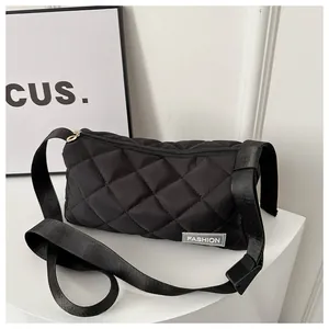 Detail of black quilted shoulder bag featuring fashion label and premium stitch texture