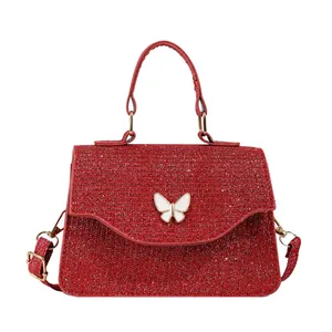 Sac à main en paillettes rouges avec ornement papillon blanc et accessoires dorés élégants