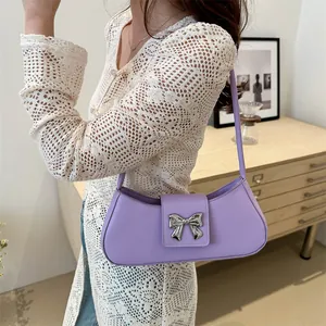 Lavender purple baguette bag with silver butterfly buckle worn on the shoulder