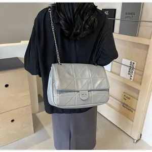 Detail der hellgrauen Stepptasche mit silberner Kette und Drehverschluss für Damen