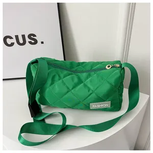 Detailed macro view of green quilted nylon fabric with diamond stitching and fashion label