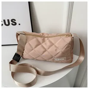 Detail of beige quilted shoulder bag featuring gold zippers and a black buckle strap