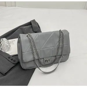 Detail der grauen gesteppten Tote-Tasche mit Silberkette und Metall-Drehverschluss