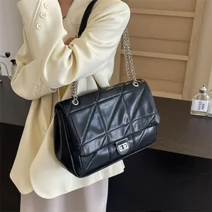 Schwarze Stepptasche mit silberner Kette und Drehverschluss am Model präsentiert