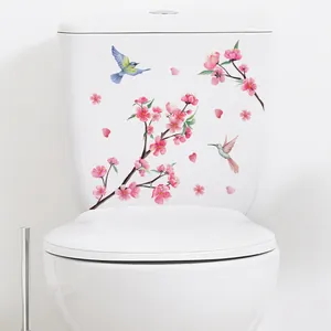 Détail des autocollants fleurs et colibris auto-adhésifs sur un réservoir de toilettes