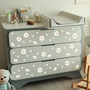 Detail von Gänseblümchen- und Herzstickern auf einer hellgrauen Kommode im Kinderzimmer