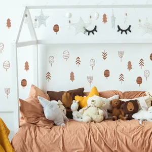 Detail of Nordic brown tree wall stickers above a nursery bed with plush toys