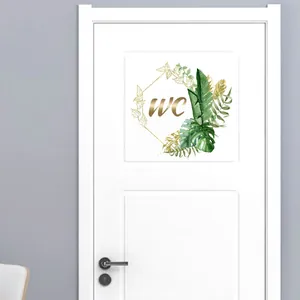 Detail of WC door sticker featuring golden lettering and green palm leaf decorative border