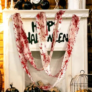 Creepy Halloween bloody gauze decoration draped over fireplace with spooky ornaments