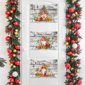 Vertical set of three festive Christmas gnomes hanging on a white door with holiday wreaths