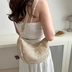 Handwoven straw crossbody bag with floral embroidery and adjustable strap