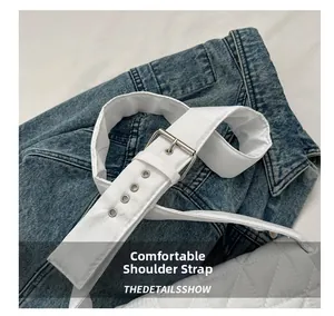 Detail view of the wide white quilted strap with a silver metal buckle and adjustment holes