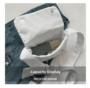 Internal capacity display of a white quilted oxford crossbody bag with metal magnetic clasp