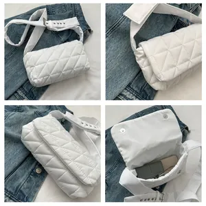 Close-up of white quilted crossbody bag with adjustable wide strap and metal hardware