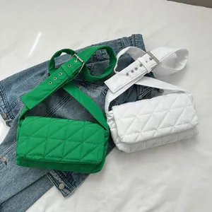 Detail of quilted oxford fabric crossbody bags in green and white colors with metal eyelets