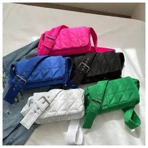 Flat lay of colorful quilted nylon crossbody bags with wide grommet straps and silver buckles