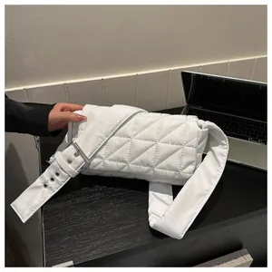Detail of white quilted crossbody bag showing thick strap with metal eyelets and grommets