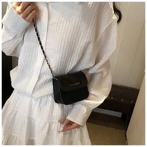 Detail of minimalist black chain bag with rich rabbit logo on a white shirt