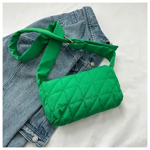 Detail of bright green quilted oxford fabric crossbody bag with adjustable wide strap
