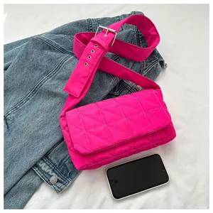 Close-up of pink quilted crossbody bag with adjustable wide strap and texture